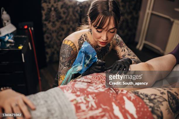 female tattoo artist working - tattooing stock pictures, royalty-free photos & images