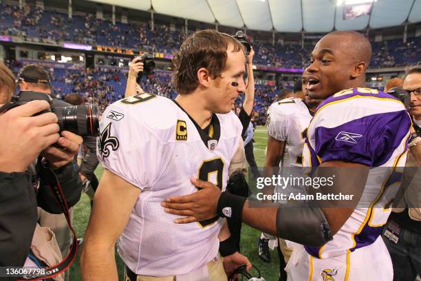 Drew Brees of the New Orleans Saints and Adrian Peterson of the Minnesota Vikings shake hands at the Hubert H. Humphrey Metrodome on December 18,...