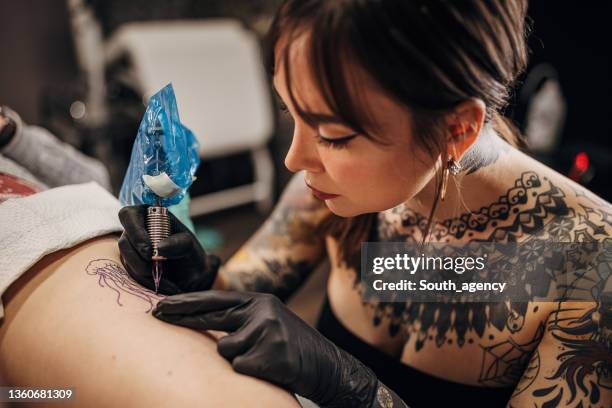 female tattoo artist working - tattoo needle stock pictures, royalty-free photos & images