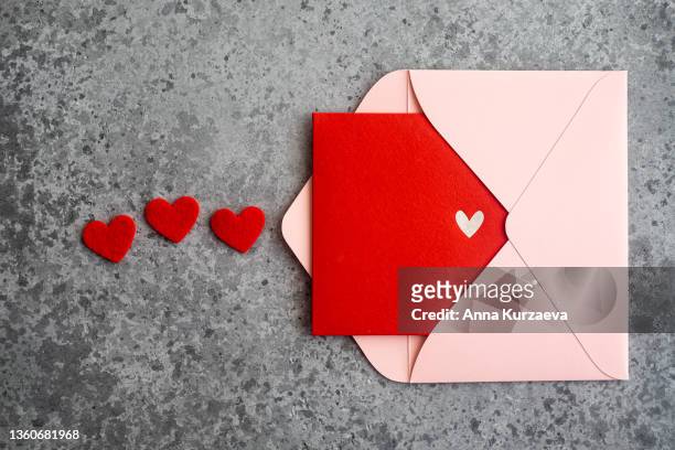 close-up of pink envelope with red postcard, top view. valentine's day card. - valentine's day holiday stock pictures, royalty-free photos & images