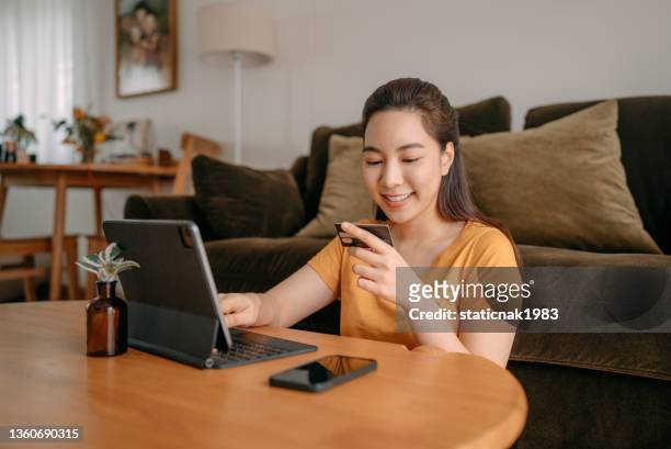 jeune femme utilisant le paiement par carte de crédit - phone credit card photos et images de collection