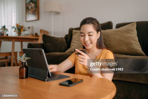 young woman using credit card payment - woman picking up toys stock pictures, royalty-free photos & images