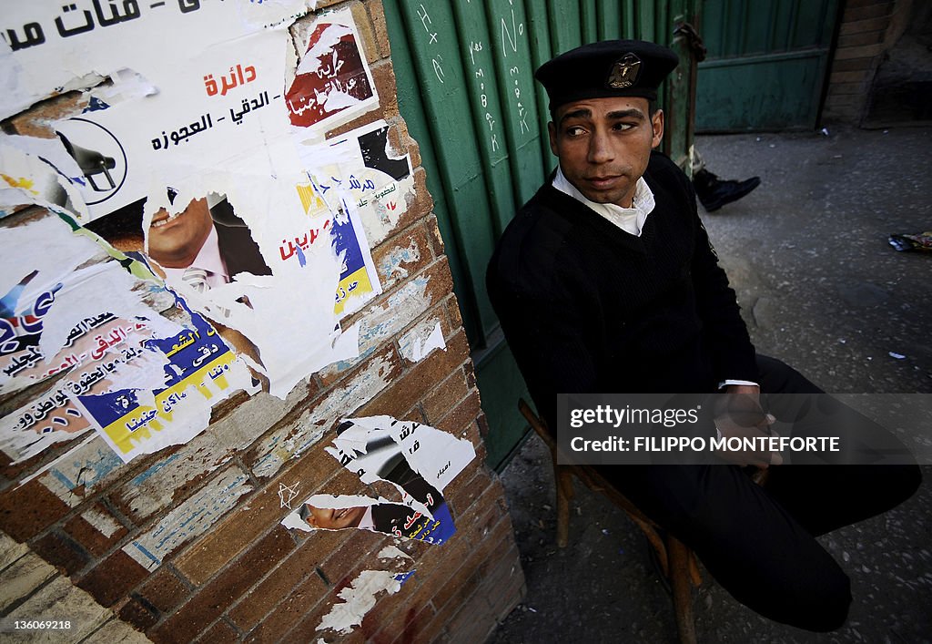 An egyptian policeman sits outside a pol