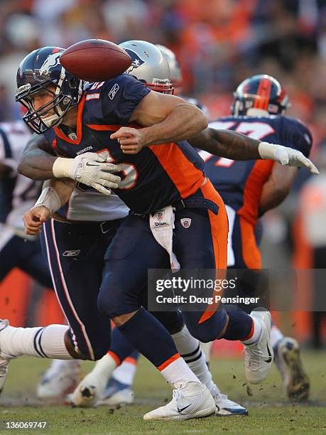 Quarterback Tim Tebow of the Denver Broncos fumbles the ball as he is hit by defensive end Mark Anderson of the New England Patriots who recovered...