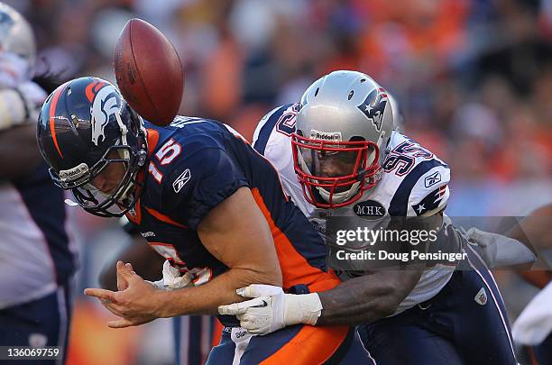 Quarterback Tim Tebow of the Denver Broncos fumbles the ball as he is hit by defensive end Mark Anderson of the New England Patriots who recovered...