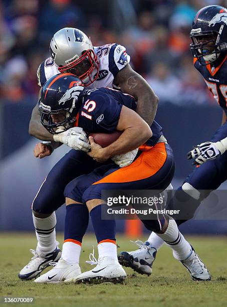 Quarterback Tim Tebow of the Denver Broncos gets sacked by defensive end Mark Anderson of the New England Patriots at Sports Authority Field at Mile...