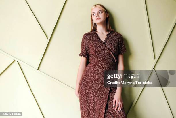 the girl in a brown dress on a light background. light background. universal abstract background. brown wrap dress. girl with blond hair. - brown blouse fotografías e imágenes de stock