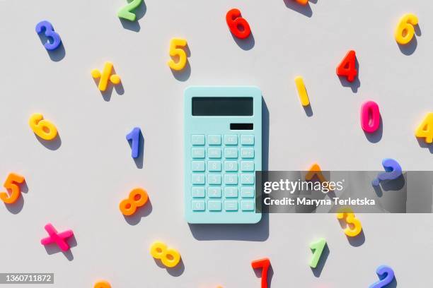 blue calculator and math symbols on a universal gray background. gray background. blue calculator. math symbols. - calculator 個照片及圖片檔