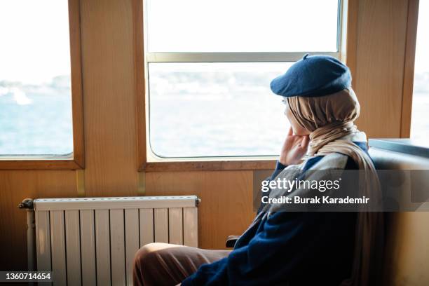 beautiful young muslim woman in hijab rides in the ferry. young female passenger sits in public transport.(daily commute) - commuter ferry stock pictures, royalty-free photos & images