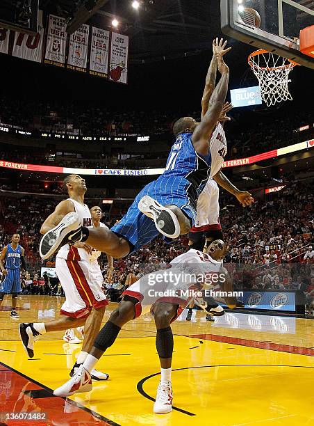 Glen Davis of the Orlando Magic commits a charge against Mario Chalmers of the Miami Heat during a preseason game at AmericanAirlines Arena on...