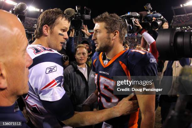 Quarterback Tom Brady of the New England Patriots talks with quarterback Tim Tebow of the Denver Broncos after the game at Sports Authority Field at...