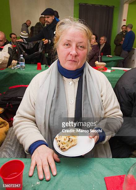 An homeless woman holds some Panettone during a Christmas Lunch perpared by the Restaurant, La Ragnatela at Centro Sociale Rivolta on December 22,...