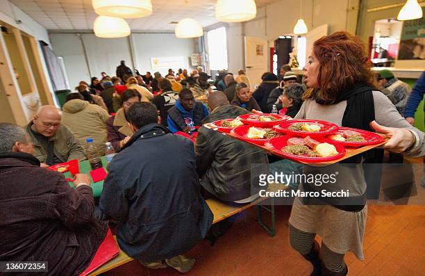 Volunteer serves Musetto and Lenticchie to homeless during a Christmas Lunch prapared by the Restaurant La Ragnatela at Centro Sociale Rivolta on...