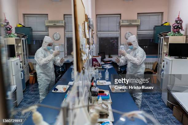 Nurse Vladislav Stamov wearing a protective equipment works in a manipulation room in the COVID-19 unit at Saint Mina Hospital on December 24, 2021...