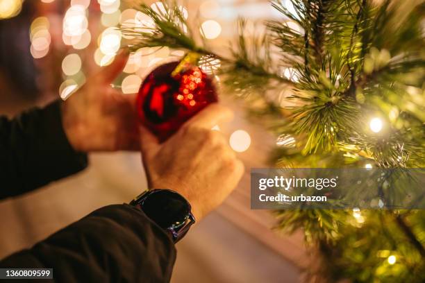 decorating the christmas tree - putting indoors stock pictures, royalty-free photos & images