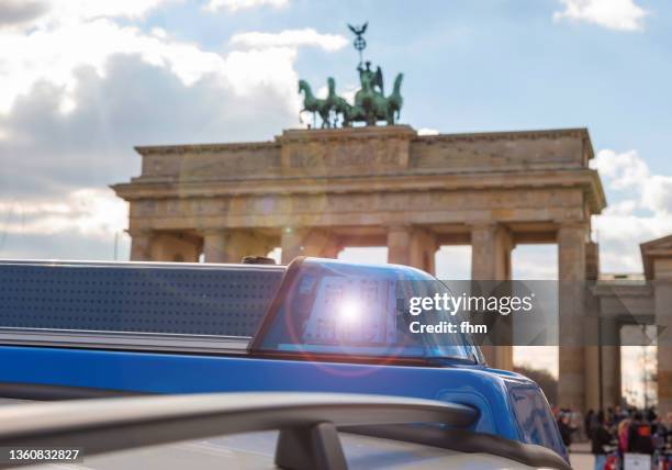 police car in front of the brandenburg gate (berlin, germany) - polizei berlin stock-fotos und bilder