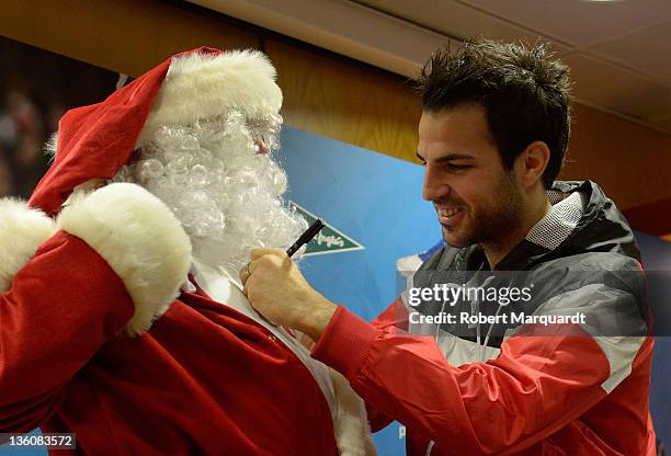 Cesc Fabregas signs Santa Claus chest during a press presentation of the new Puma PowerCat 1.12 shoe at the Corte Ingles store on December 23, 2011...