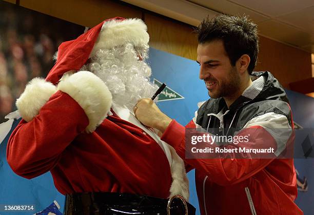 Cesc Fabregas autographs Santa Claus chest during a press presentation of the new Puma PowerCat 1.12 shoe at the Corte Ingles store on December 23,...