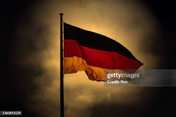 german flag with dramatic sky - mass murder stock pictures, royalty-free photos & images