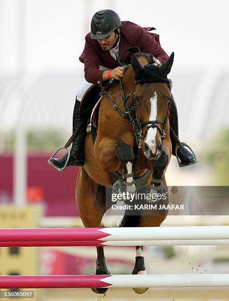 Qatar's Ali al-Rumaihi competes with Ravenna 323 in the individual jumping equestrian final at the 2011 Arab Games in the Qatari capital Doha on...