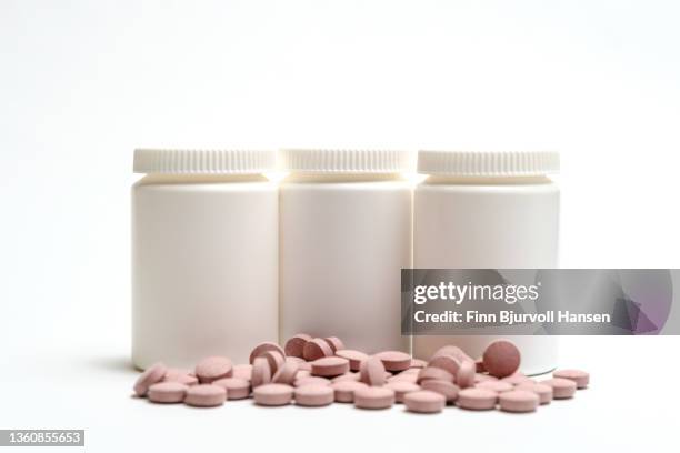 three neutral white pill boxes. isolated against white background. neutral pink pills in front of the boxes - finn bjurvoll stock pictures, royalty-free photos & images