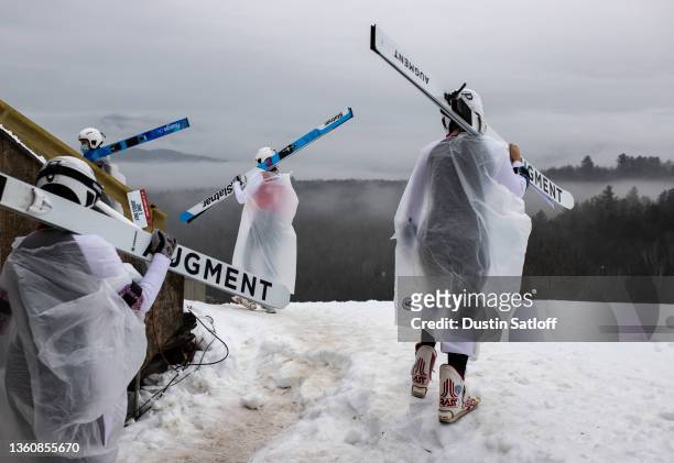 Competitors walk to the jump in the rain before the start of the second trial round of the ski jumping competition at the U.S. Nordic Combined & Ski...