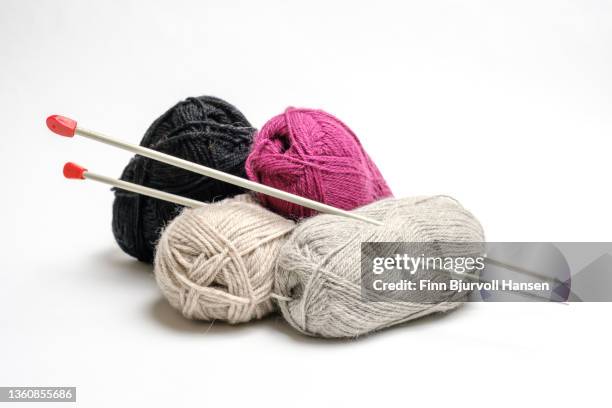 four bundles of knitting yarn and knitting needles in different colors. isolated against a white background - ball of wool stock pictures, royalty-free photos & images