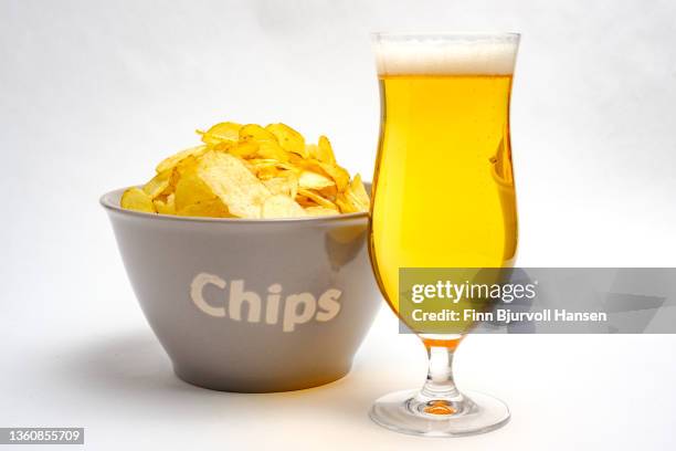 gray bowl with potato chips and a glass of light beer. isolated against a white background - finn bjurvoll stock pictures, royalty-free photos & images