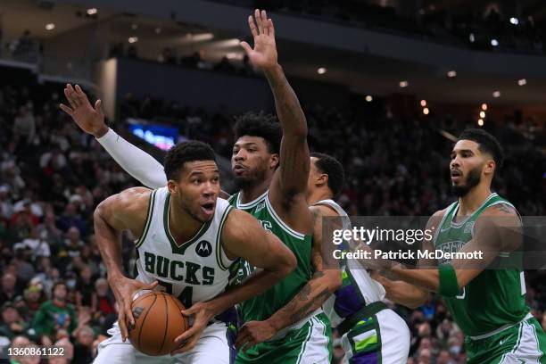 Giannis Antetokounmpo of the Milwaukee Bucks dribbles the ball against Marcus Smart of the Boston Celtics in the second half at Fiserv Forum on...