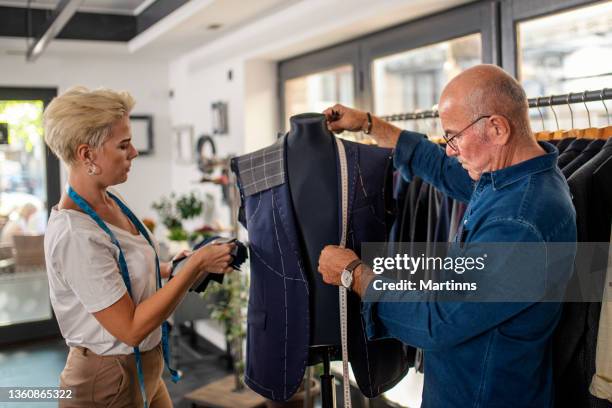 dois alfaiates profissionais medindo material e trabalhando em um terno - custom tailored suit - fotografias e filmes do acervo