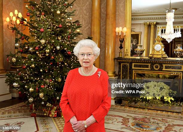 Queen Elizabeth II stands in the 1844 Room of Buckingham Palace after recording her annual Christmas Day television broadcast to the Commonwealth on...