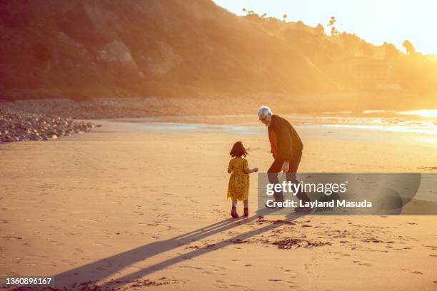 grandpa and granddaughter play - us girls on the beach stock-fotos und bilder