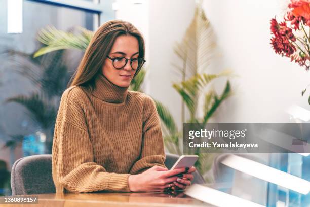 young stylish businesswoman in smart glasses is using mobile phone for texting - smart glasses eyewear foto e immagini stock