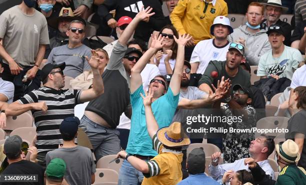 Spectators fail to catch a ball hit for six by Ben Stokes of England during day one of the Third Test match in the Ashes series between Australia and...