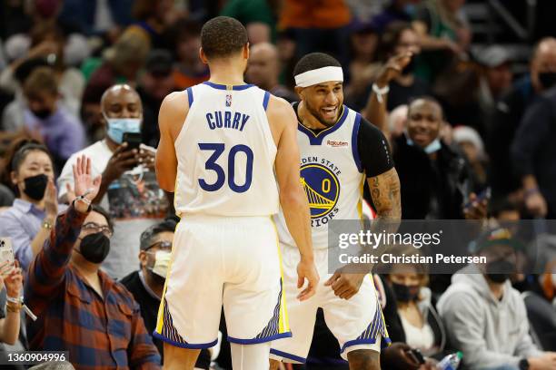 Gary Payton II of the Golden State Warriors celebrates with Stephen Curry after defeating the Phoenix Suns in NBA game at Footprint Center on...