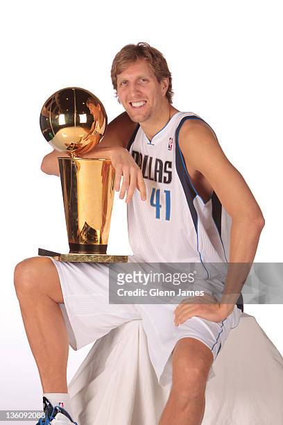 Dirk Nowitzki of the Dallas Mavericks poses for a portrait with the Larry O'Brien Trophy during media day at the American Airlines Center on December...