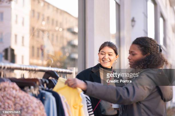 two woman friends shopping for clothes in store - beautiful filipino women stock pictures, royalty-free photos & images