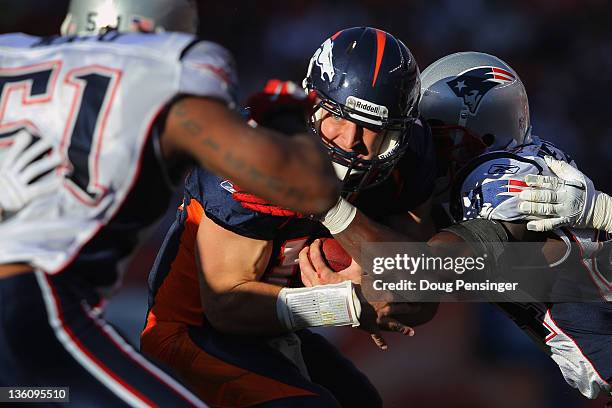 Quarterback Tim Tebow of the Denver Broncos is tackled by strong safety James Ihedigbo of the New England Patriots at Sports Authority Field at Mile...