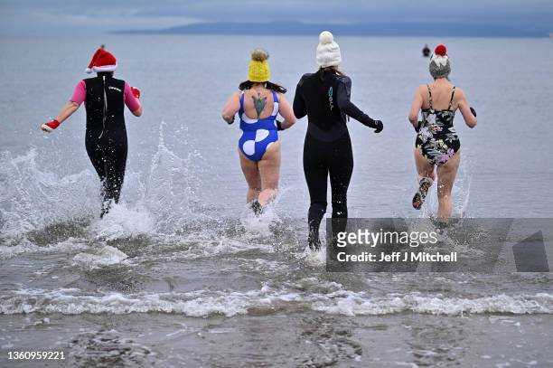 Swimmers take part in a charity Boxing Day swim at Ayr beach for Ayrshire Cancer Support on December 26, 2021 in Ayr, Scotland. New restrictions are...