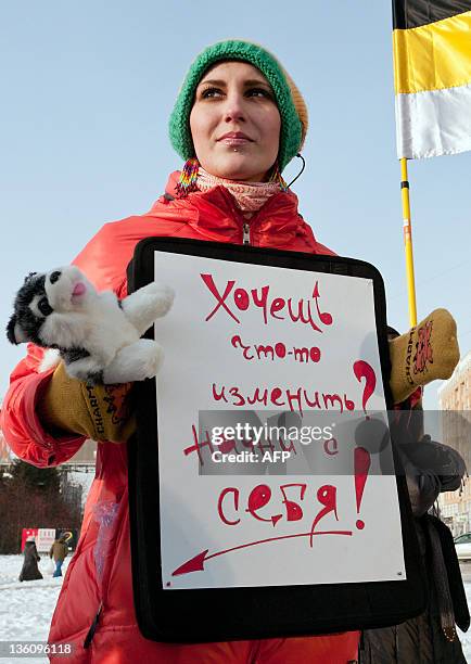 Woman holds a poster reading: "If you want to change anything start from yourself!" during a protest against the December 4 allegedly rigged...