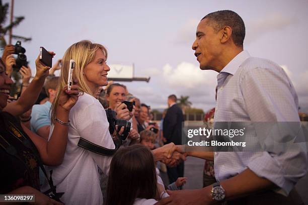 President Barack Obama greets attendees as he arrives at Joint Base Pearl Harbor-Hickam in Honolulu, Hawaii, U.S., on Friday, Dec. 23, 2011....