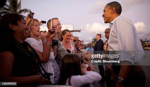 President Barack Obama greets attendees as he arrives at Joint Base Pearl Harbor-Hickam in Honolulu, Hawaii, U.S., on Friday, Dec. 23, 2011....