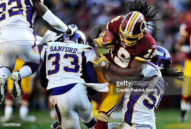 Wide receiver Jabar Gaffney of the Washington Redskins is hit by safety Jamarca Sanford of the Minnesota Vikings and Erin Henderson in the second...