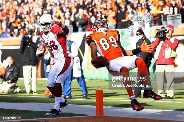 Jerome Simpson of the Cincinnati Bengals jumps over Daryl Washington of the Arizona Cardinals for a 19-yard touchdown during first half action at...