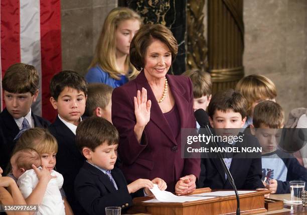 Surrounded by children, House Speaker Nancy Pelosi, Democrat of California, raises her hand as she is sworn-in 04 January 2007 during 110th Congress...