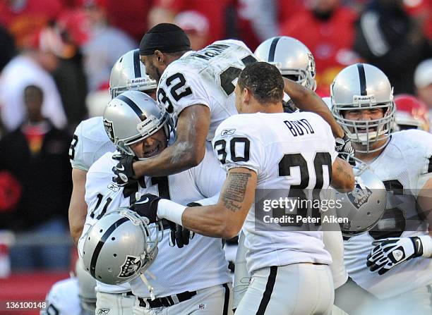 Place kicker Sebastian Janikowski of the Oakland Raiders celebrates with his teammates after kicking the winning field goal against the Kansas City...