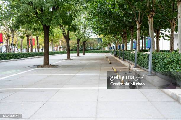 electric vehicle charging station under the shade - stationnement photos et images de collection