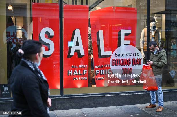Members of the public are seen shopping during the Boxing Day sales on December 26, 2021 in Glasgow, Scotland. New restrictions are being introduced...