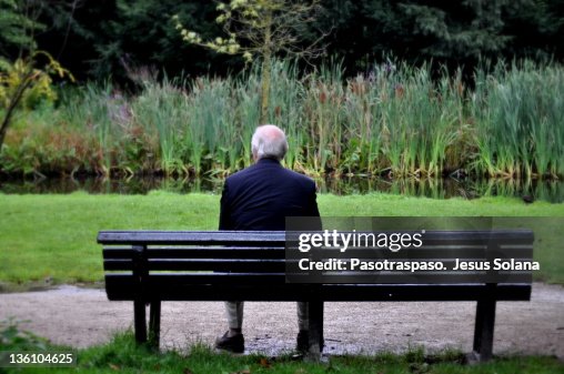 Senior man sitting on bench in garden Senior man sitting on bench in garden