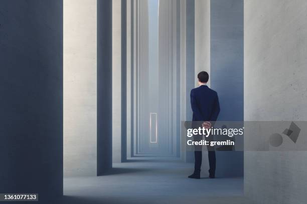 abstract businessman watching behind concrete pillar - stalker person stock pictures, royalty-free photos & images
